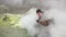 Man sits by fumarole in volcano