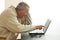 A man sits looking very surprised with open mouth as he points to the screen of a notebook computer. He reads or sees someting ver