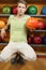 Man sits near shelves with balls and holds ball