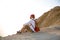 A man sits overlooking a panoramic view of a beautiful coastline