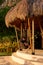 A man sits in a rocking-egg in a straw pergola enjoying the sunset