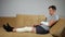 Man sits on sofa with injured knee and broken forearm