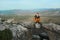 Man sits on a stone arch on Mangup plateau in Crimea