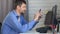 A man sits at a table and communicates via video communication via telephone