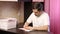 A man sits at a table and signs greeting cards. Self-isolation during a pandemic