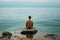 man sitting alone on the ocean shore