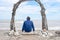 Man sitting on beach on a piece of driftwood