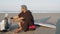 Man sitting on beach and putting on prosthesis leg for sports