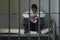 Man Sitting On Bed In Prison Cell