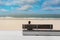 man sitting on a bench facing the beach of the city of Calais and its lighthouse