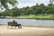 A man sitting on the bench near the river. Resting near the riverside