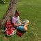 Man sitting beneath the tree and using his tablet