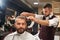 Man sitting in chair in barber shop during process of haircut