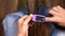 man sitting on chair using pulse oximeter, top view