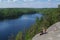 Man sitting on cliff relaxing, above the lake Yastrebinoye, Priozersky district, Leningrad region, Russia