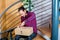 Man sitting in corridor and opening a package