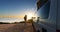 man sitting with digital device at his Transporter Camping Van bus at the California Ocean in the coastal Nature - digital nomad