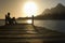 Man Sitting On Dock By Lake