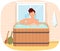 Man sitting in font with hot water. Guy taking bath and having rest in wooden barrel at free time