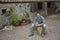 Man Sitting On Haybale Outside Stable