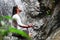 Man sitting in meditation yoga on rock at waterfall in tropical