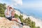 Man sitting in mountains looking through binoculars