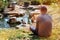 Man is sitting near the pond with duck in the botanic park