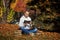 Man sitting in  Park with laptop, Notepad, books and textbooks. Outdoor learning, social distancing