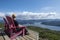 Man Sitting in a Red Adirondack Chair on Top of the Lookout Trail