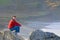 Man Sitting on Rocky Beach