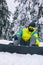 man sitting on snowed ground with snowboard