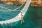 Man sitting at suspension bridge enjoying sea view and nature calmness