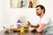 Man sitting at table during breakfast and dreamy looking away in kitchen