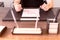 Man sitting at table and holds pen in his hand. There are sheet of paper with a trading chart on the table. Concept photo.