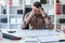 A man is sitting at a table in the office and looks at the graph on a magnetic board.