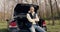 A man sitting on the trunk of the car in the woods