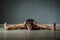 A man sitting on a twine in a yoga pose. The man reaches his heels with his hands.