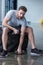 Man sitting on tyre and exercising with small dumbbells