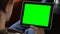 Man Sitting Using Blank Large Green Screen Tablet