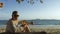 Man sitting in white dress drinks pineapple cocktail Pina Colada on beach. Concept rest sea, tropical resort traveling