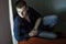 Man sitting on wooden stairs low-key lighting portrait