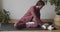 Man sitting on yoga mat cross legged stroking fluffy cat indoors natural light slow motion. Yogi master relaxing before