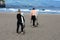 A man and a are skating on a surfboard. Beautiful beach of Praia do Areal de Santa Barbara, San Miguel, Azores.