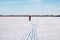 Man on ski trip. Man in winter tracksuit skiing on frozen lake on frosty clear winter day, blue sky