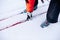 Man is skiing. Close-up of legs in gray ski boots on skis, man bent down and picked up ski lying on snow