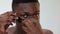 Man skincare african guy applying black eye patch
