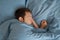 Man sleeping in bed in the morning rest for healthy wellness in bedroom at home. Tired exhausted male asleep or dreaming