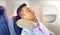 Man sleeping in plane with cervical neck pillow