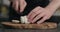 Man slicing fresh mozzarella cheese on olive wood board