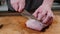 Man slicing pork meat on a table, working process closeup. Healthy, food.